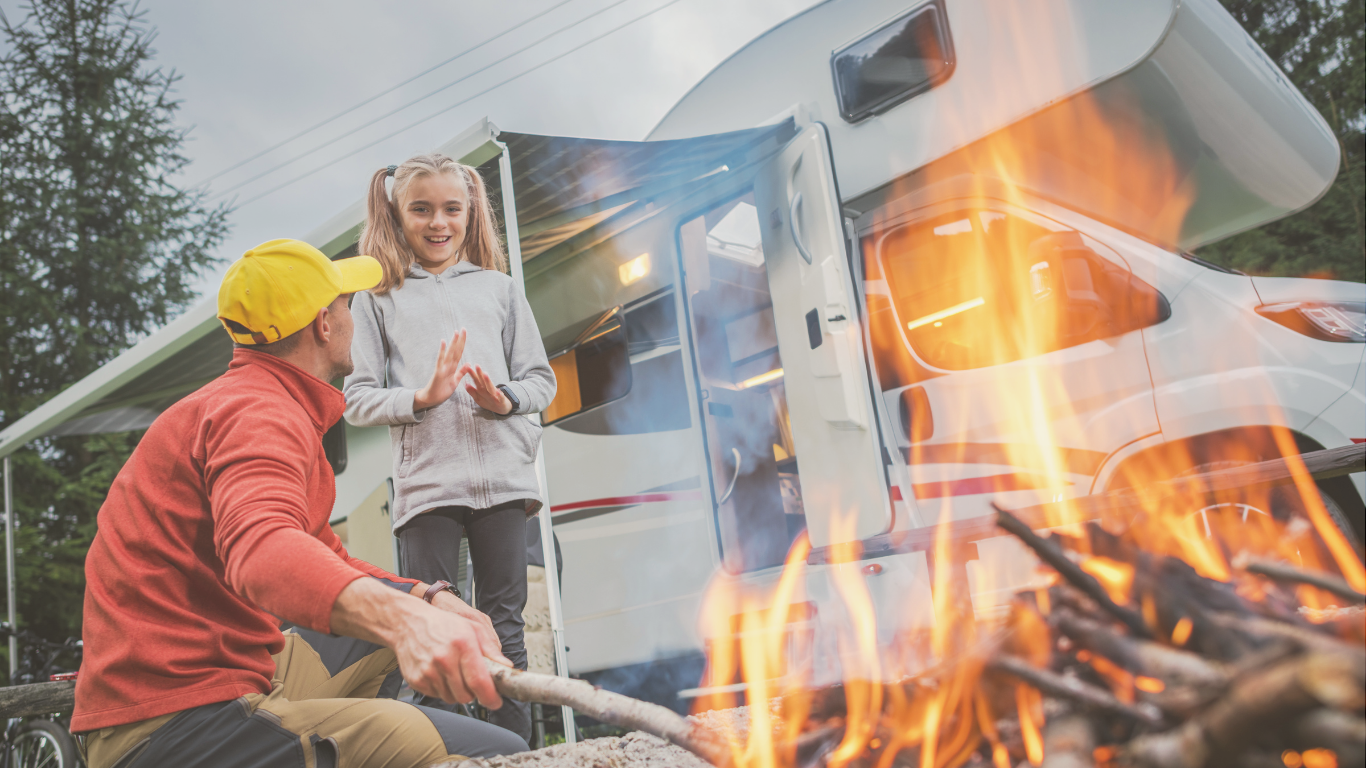 A family gathered around a campfire beside their RV while boondocking off-grid, enjoying quality time in nature.