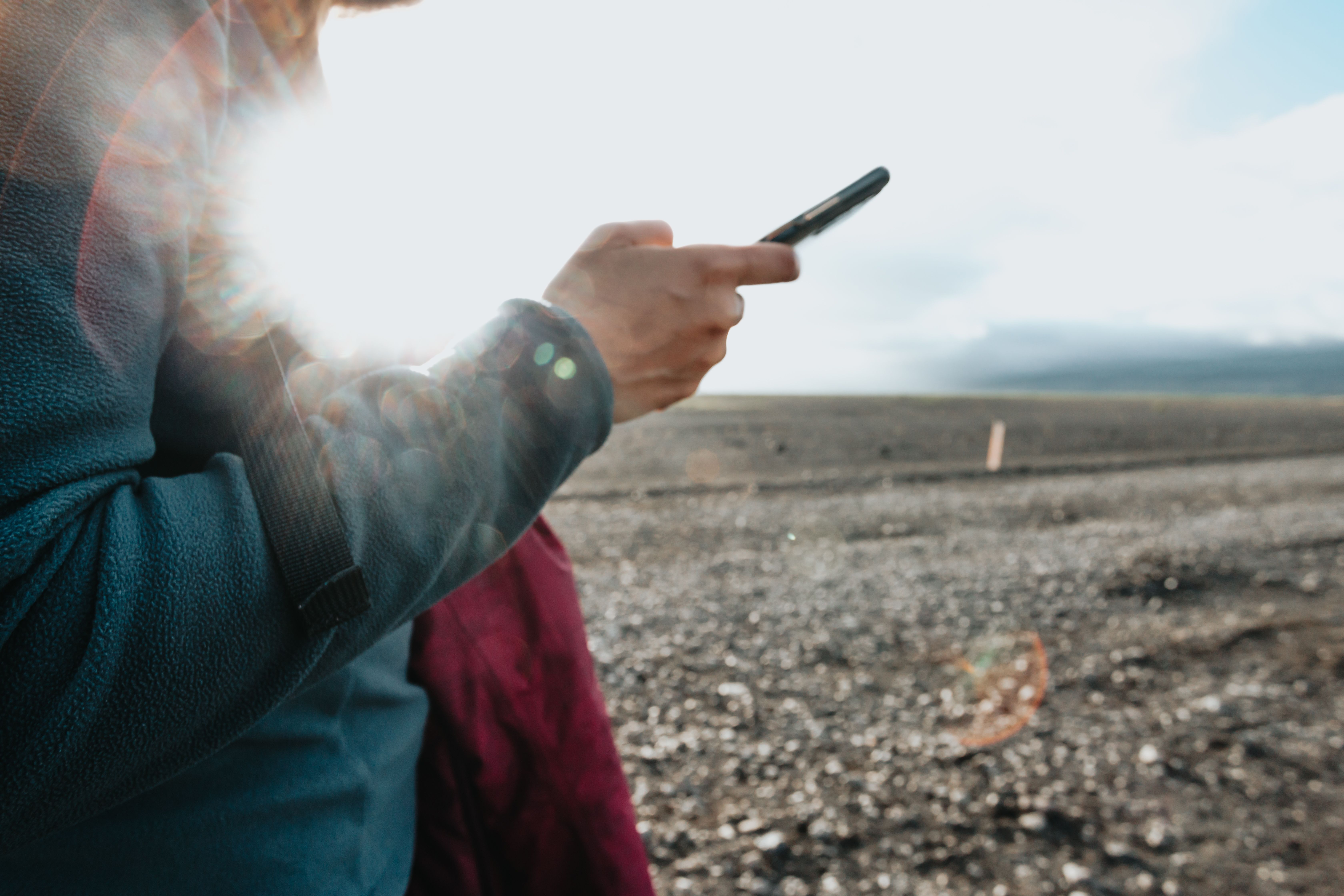 woman holding a cell phone while rv traveling to represent contacting us